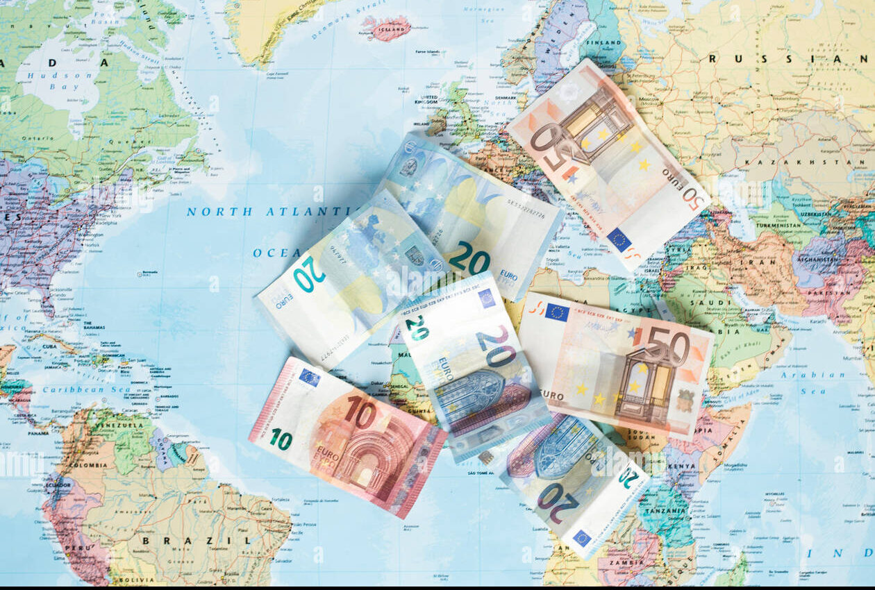 A map of the world with Euro banknotes scattered across it, symbolizing global financial markets.