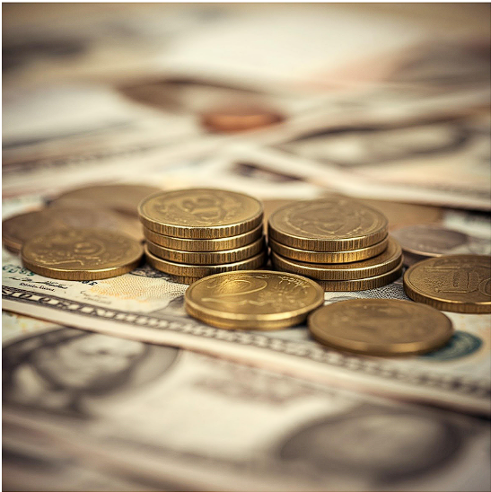 Stacks of gold coins and various currency notes arranged on a surface, symbolizing global financial markets and trading strategies.